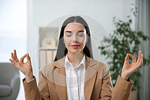 Young woman meditating at workplace. Stress relief