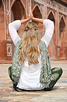 Young woman meditating in the yard of Humayun's Tomb. Delhi