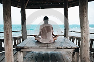 Young woman meditating in a yoga pose at the beach