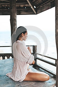 Young woman meditating in a yoga pose at the beach