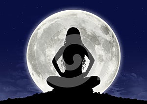 Young woman in meditation at the full moon photo
