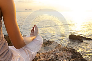 Young woman meditation in yoga pose on the tropical beach