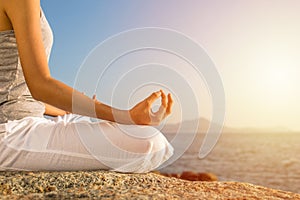 Young woman meditation yoga pose on tropical beach with sunlight