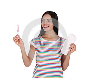 Young woman with menstrual pad and tampon on white background