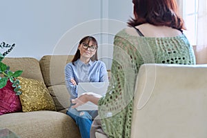 Young woman at mental therapy session with female psychologist, in office