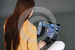 Young woman mobile developer writes program code on a computer, programmer work