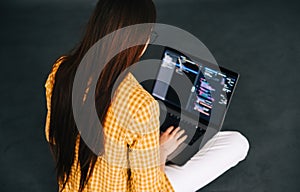 Young woman mobile developer writes program code on a computer, programmer work