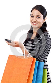 Young woman with mobile phone and shopping bags