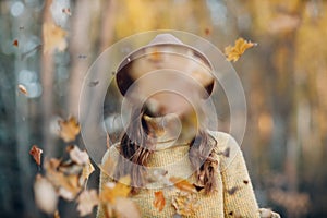 Young woman model in autumn park with yellow foliage maple leaves. Fall season fashion.