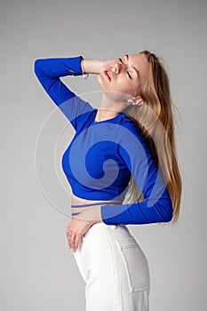 Young Woman model in Blue Top and White Pants posing on white background