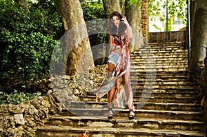 Young woman, model of fashion, in a garden stairs