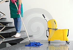 Young woman with mop cleaning