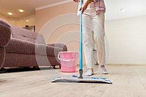 young woman mopping floor at living room