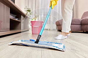young woman mopping floor at living room