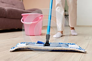 young woman mopping floor at living room