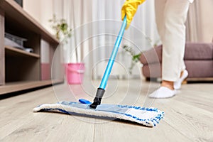 young woman mopping floor at living room