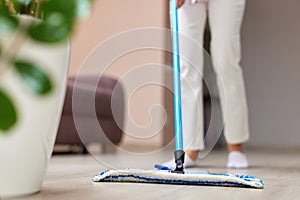 young woman mopping floor at living room