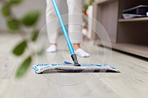 young woman mopping floor at living room