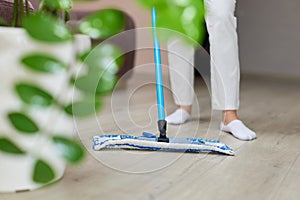 young woman mopping floor at living room