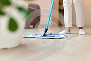 young woman mopping floor at living room