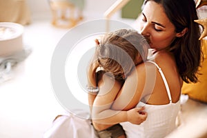 Young woman mother expressing love to little baby,mom kissing sleeping child in hands