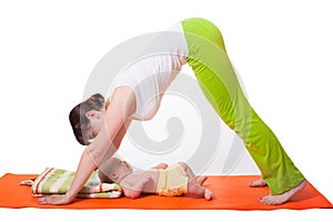 Young woman mother practicing yoga with baby