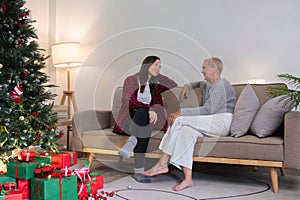 Young woman and mother sitting and talking in living room with Christmas tree and gift boxes. young woman talking Relax