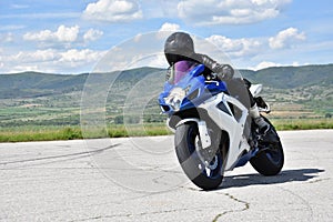 Young woman motorcyclist speeding on tarmac racetrack