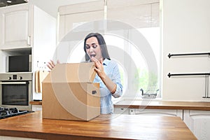 Young woman with moving box in her house moving in