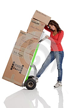 Young woman moving boxes with with a hand truck or dolly.