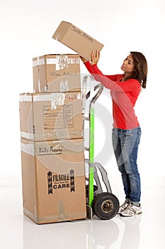 Young woman moving boxes with with a hand truck or dolly.