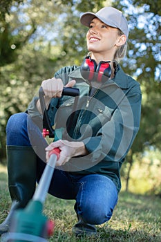 young woman mowing grass