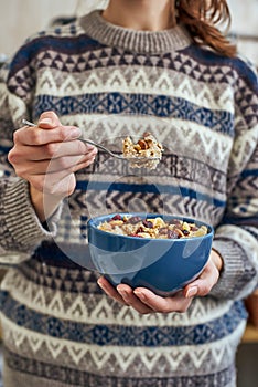 Young woman with muesli bowl. Healthy snack or breakfast in the morning.