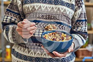 Young woman with muesli bowl. Healthy snack or breakfast in the morning.