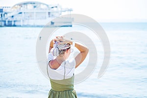 Young woman with multi-colored dreadlocks stands on the beach