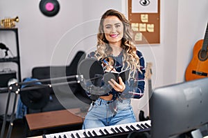 Young woman musician composing song at music studio