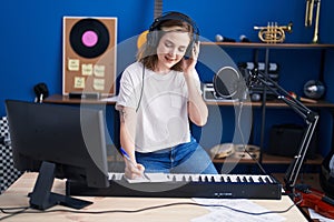 Young woman musician composing song at music studio
