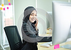 Young woman muslim work in office using phone