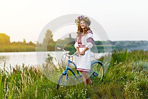 Young woman in national ukrainian folk costume with bicycle