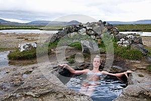 Young woman in natural hot spring in Iceland