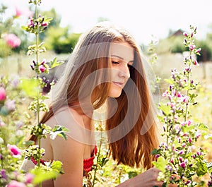 Young woman at nature, surrounding by wild mallows