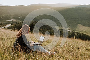 Young women with laptop and mask in the nature
