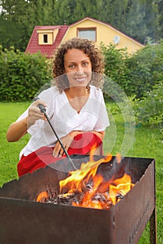 Young woman near brazier on picnic photo