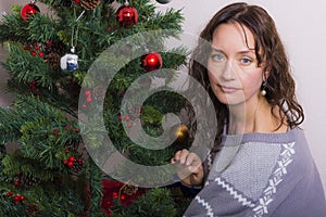 Young woman near decorated Christmas tree