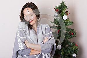 Young woman near decorated Christmas tree