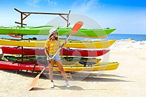Young woman near kayaks at sunny day