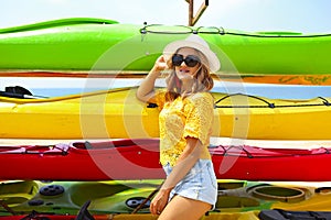 Young woman near kayaks at sunny day