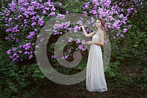 Young woman near a lilac bush.