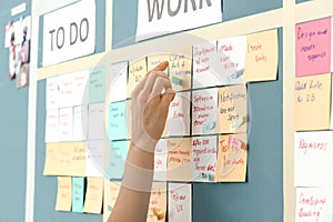 Young woman near scrum task board in office