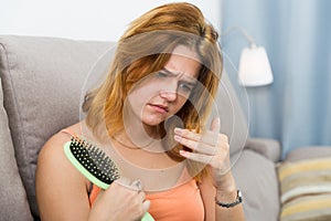 Young woman is nervous because her hair suffers from avitaminosis